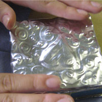 glue embossed tin onto felt